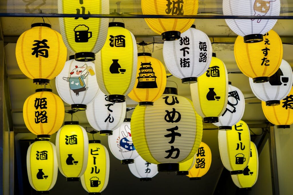 Vibrant Japanese paper lanterns with Kanji characters hanging at night.